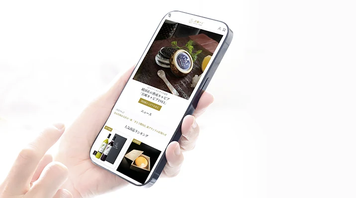 スマホに高級ナビオンラインストアのTOPページが映っている写真